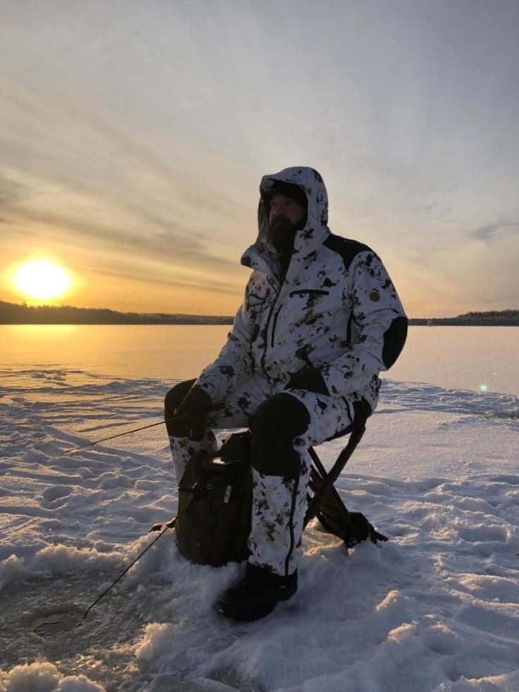 Man with naruska snow camo hunting suit in ice fishing