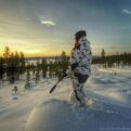 Naruska lumicamo metsästyspuku naismallin päällä talvisessa maastossa