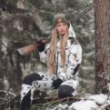 A woman hunting wearing a Naruska snow camo hunting suit