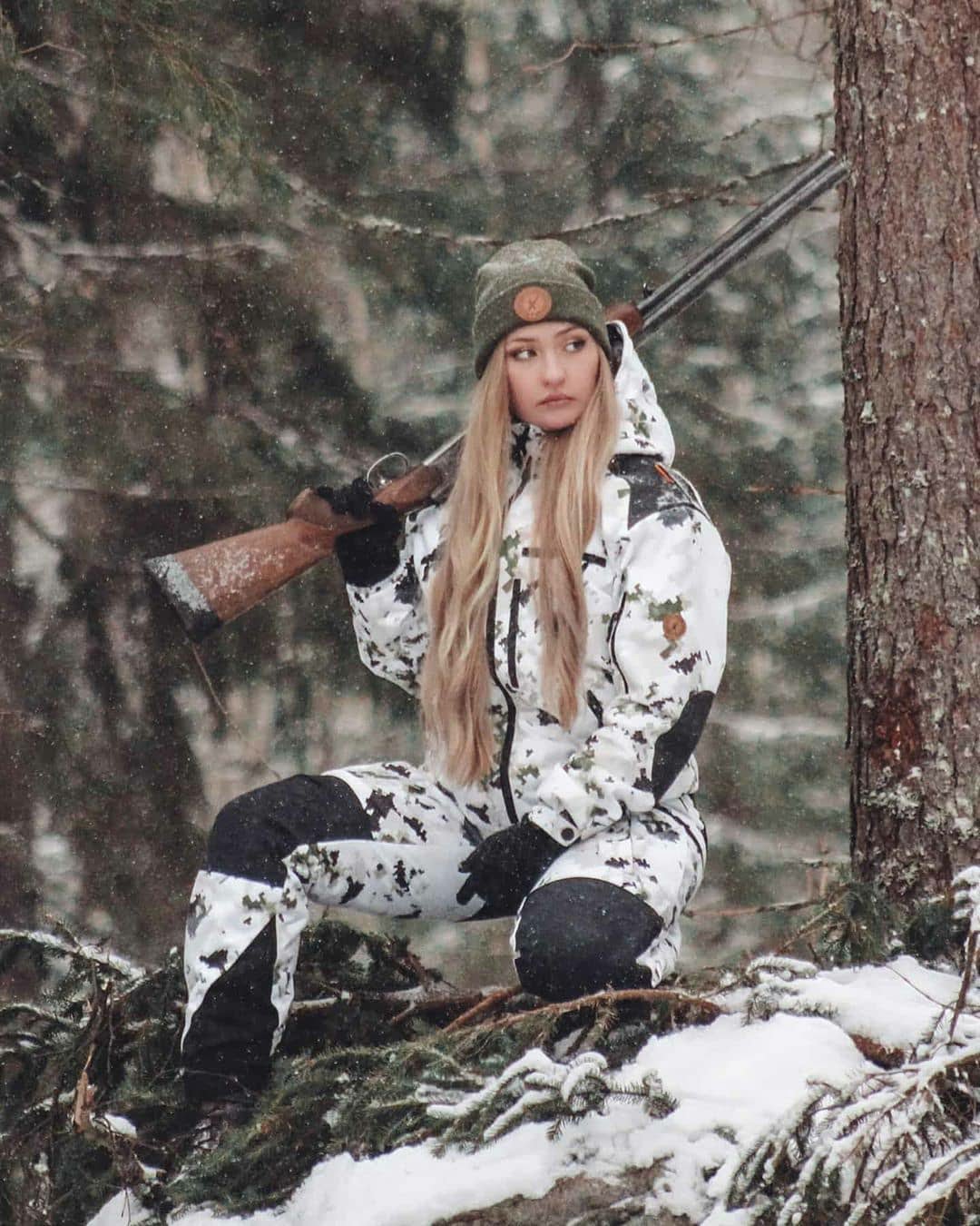 Naruska lumicamo metsästyspuku naisen päällä metsällä