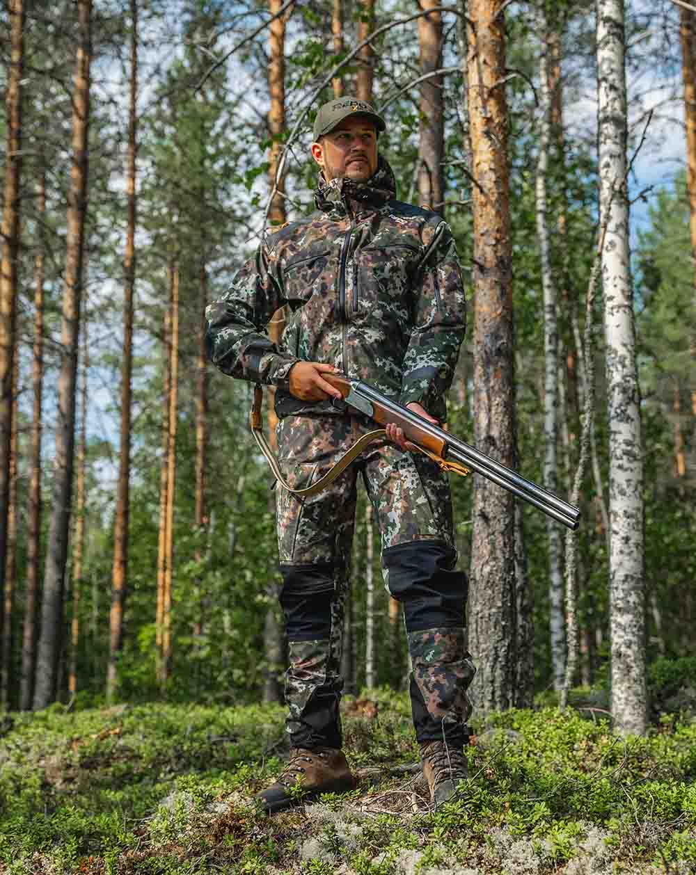 Alpha G1 M05 metsästyshousut mallin päällä metsämaisemassa